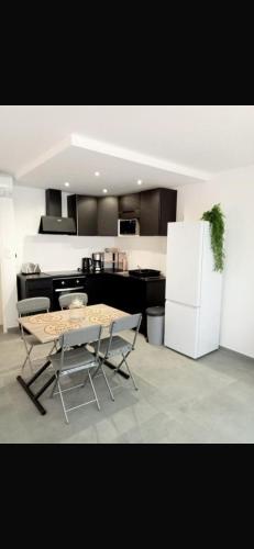 une cuisine avec une table et un réfrigérateur blanc dans l'établissement Boetman, à Saint-Raphaël