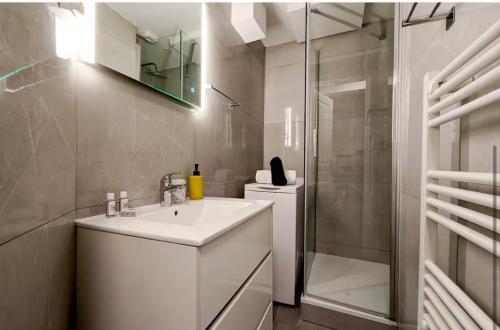 une salle de bain blanche avec un lavabo et une douche dans l'établissement Boetman, à Saint-Raphaël