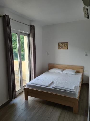 una cama en una habitación con una ventana grande en Vila Armenko, en Buljarica