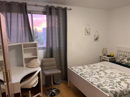 a bedroom with a bed and a desk and a window at 2 Superbes chambres d hôte dans un appartement avec magnifique vue sur Paris in Sucy-en-Brie