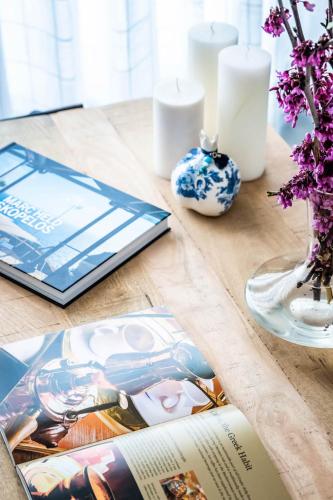a book on a wooden table with candles and flowers at Marani Home & Villas in Skopelos Town
