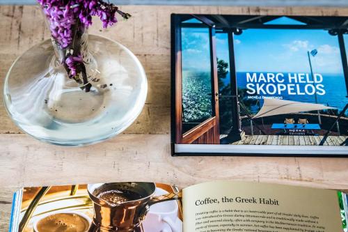 a book and a vase with flowers and a book at Marani Home & Villas in Skopelos Town