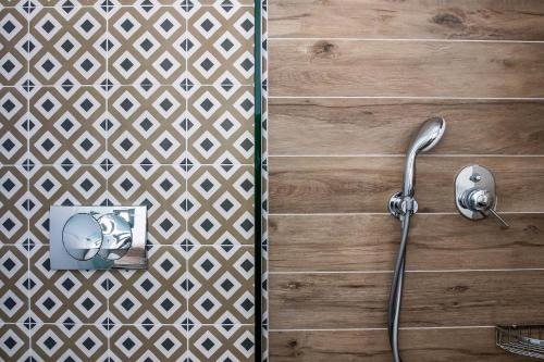 a shower with a hose attached to a wooden wall at Marani Home & Villas in Skopelos Town