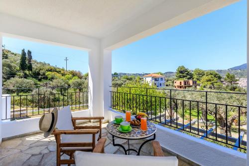 a room with a balcony with a table and chairs at Marani Home & Villas in Skopelos Town