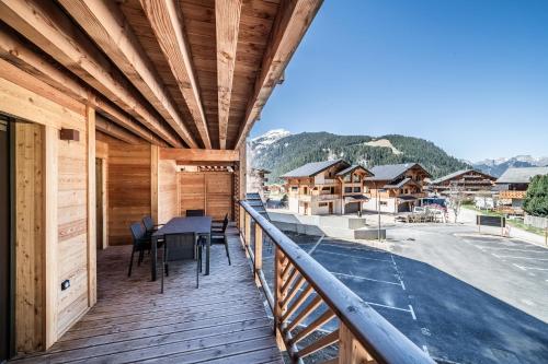 a wooden balcony with a table and chairs on it at Apartment Montami, Châtel - by EMERALD STAY in Châtel