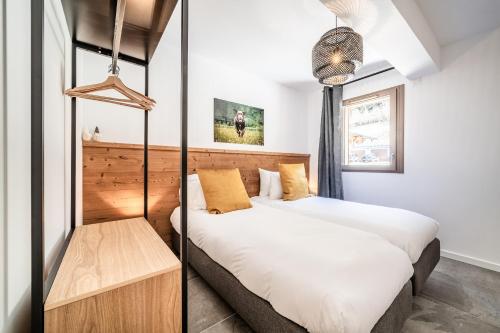 a bedroom with two beds and a table at Apartment Montami, Châtel - by EMERALD STAY in Châtel