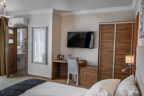 a hotel room with a desk and a television at Moris Boutique Beach Hotel in Gdańsk