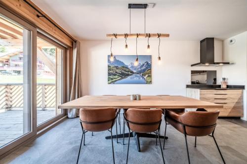 a kitchen and dining room with a wooden table and chairs at Apartment Montami, Châtel - by EMERALD STAY in Châtel