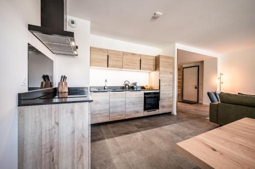 a kitchen with wooden cabinets and a living room at Apartment Montami, Châtel - by EMERALD STAY in Châtel