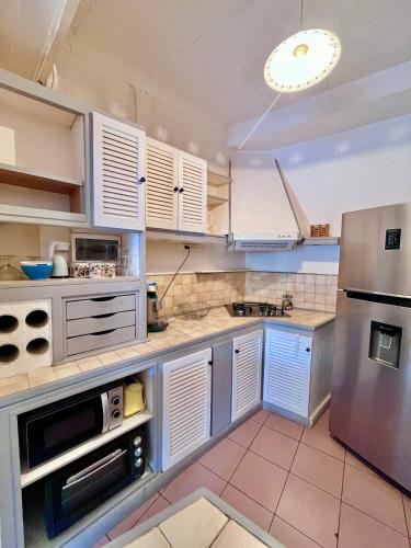 une cuisine avec des armoires blanches et un réfrigérateur en acier inoxydable dans l'établissement BEAU STUDIO pour 4 p à 5 mn de la plage, à Villeneuve-Loubet