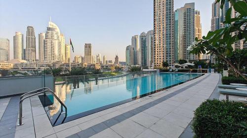 a swimming pool with a city skyline in the background at Luxury 4BR Full Burj khalifa & Fountain View, 1Gbps, PS5 in Dubai