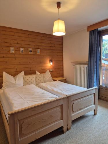 a bedroom with a large bed with a wooden headboard at Garni Cir in Santa Cristina in Val Gardena