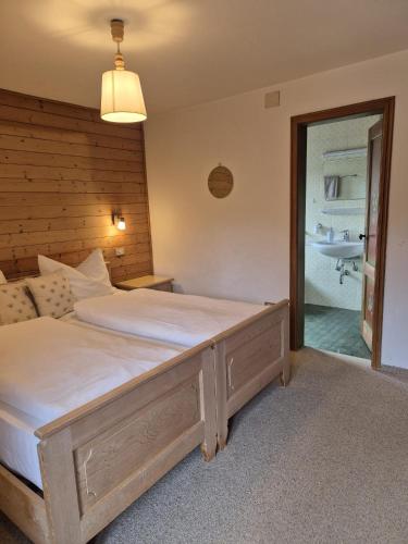 a bedroom with a large bed and a bathroom at Garni Cir in Santa Cristina in Val Gardena