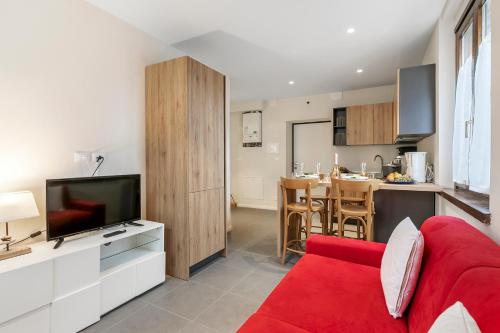 a living room with a red couch and a kitchen at Appartamento 30 NODI Torbole - Happy Rentals in Nago-Torbole