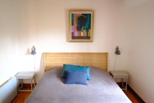 une chambre avec un lit avec un oreiller bleu dessus dans l'établissement Le Bray, à Colleville-sur-Mer