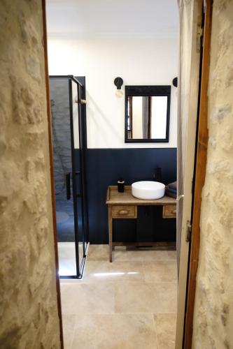 une salle de bain avec un lavabo et un miroir dans l'établissement Le Bray, à Colleville-sur-Mer