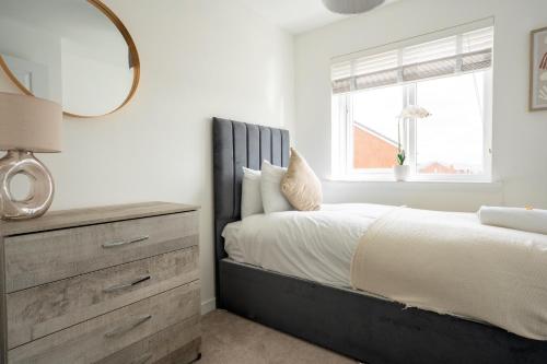 a bedroom with a bed with a mirror and a dresser at Bartonshill House in Glasgow