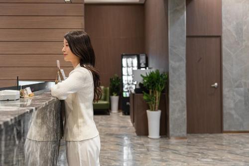 a woman standing at a counter in a lobby at Incheon BrownDot Hotel Guwol in Incheon