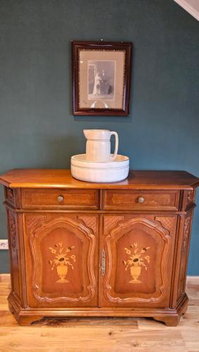 a wooden cabinet with a vase on top of it at Villa Elbling in Radebeul