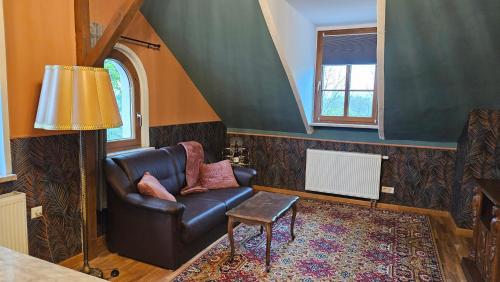 a living room with a leather chair and a window at Villa Elbling in Radebeul