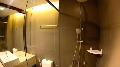 a bathroom with a shower with a toilet and a sink at Dancenter Bangkok Cha Cha Suite in Bangkok