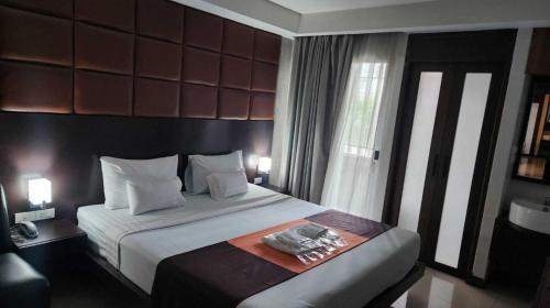 a bedroom with a large bed with two towels on it at Dancenter Bangkok Cha Cha Suite in Bangkok