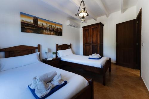 a bedroom with two beds and a chandelier at Villa con piscina, BBQ, terraza y wifi in Santanyi