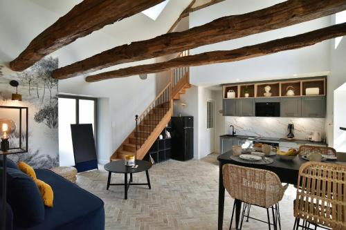 un salon avec un canapé bleu et une table dans l'établissement Lys'toire - Grand Jardin, à Dinan