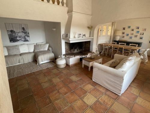 Elle comprend un salon doté d'un mobilier blanc et d'une cheminée. dans l'établissement Villa 4 étoiles - parking - wifi - clim - piscine, à Sainte-Maxime