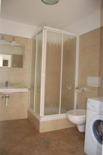 a bathroom with a shower and a toilet and a sink at Apartmenthaus am Waalweg in Caines