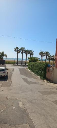 an empty street with palm trees in the distance at Rosa dei venti in Porto Empedocle