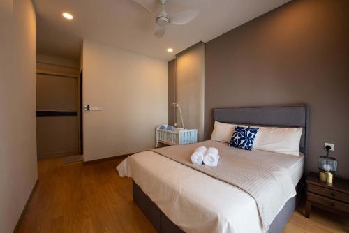 een slaapkamer met een bed met twee handdoeken erop bij Comfy 3BR Apt in Danga Bay FREE Parking Sea View in Johor Bahru