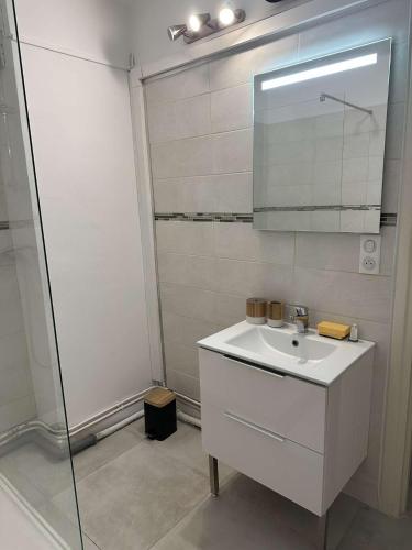 une salle de bain blanche avec un lavabo et une douche dans l'établissement Lallie, à Bastia