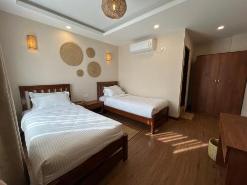 une chambre d'hôtel avec deux lits et une table dans l'établissement Lhamhendo Retreat, à Mārkhu