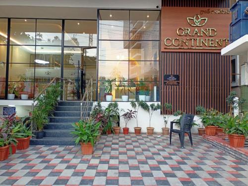 a store with potted plants in front of a building at Hotel Grand Continent Gachibowli - US Consulate in Gachibowli