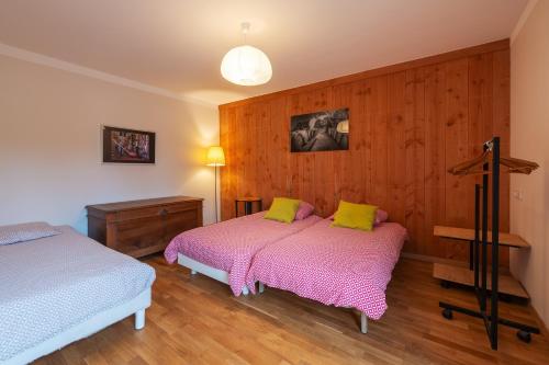 deux lits dans une chambre aux murs en bois dans l'établissement Domaine Fouet - A 100m du Domaine visite de cave et dégustation gratuite, à Saint-Cyr-en-Bourg