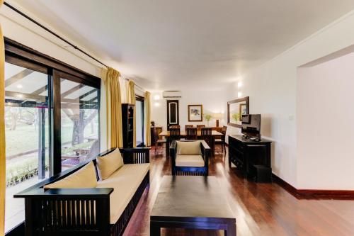 a living room with a couch and a table at Cinnamon Lodge Habarana in Sigiriya