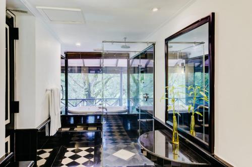 a bathroom with a glass shower and a black and white floor at Cinnamon Lodge Habarana in Sigiriya