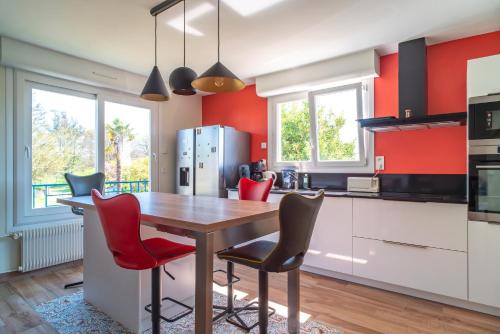 - une cuisine avec une table en bois et des murs rouges dans l'établissement La Mer Blanche - Proche de la mer avec jardin, à Bénodet