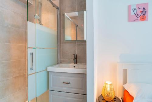 une salle de bain avec un lavabo et un miroir dans l'établissement La Mer Blanche - Proche de la mer avec jardin, à Bénodet