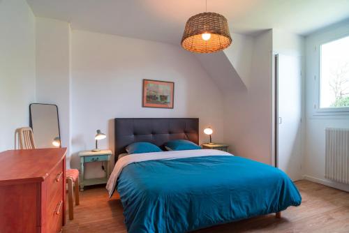 - une chambre avec un lit bleu et une couverture bleue dans l'établissement La Mer Blanche - Proche de la mer avec jardin, à Bénodet