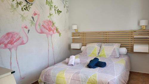 1 dormitorio con 1 cama con flamencos rosas en la pared en Carestella, en Porto Vecchio