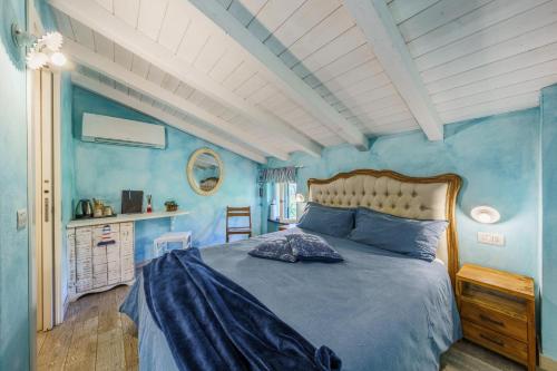 a bedroom with blue walls and a large bed at La Rocca Maison de Charme in Moneglia