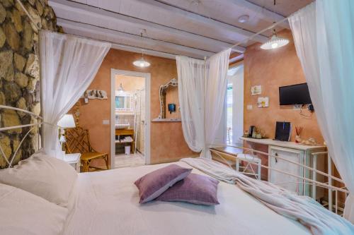 a bedroom with a white bed with curtains and a desk at La Rocca Maison de Charme in Moneglia