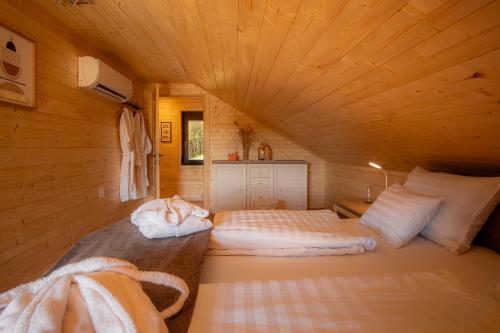 a bedroom with two beds in a wooden cabin at Era's Home Apartman in Apátistvánfalva
