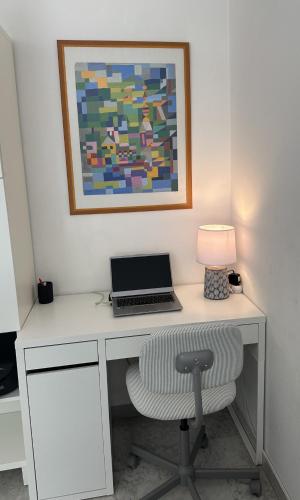 - un bureau avec un ordinateur portable et une chaise avec une lampe dans l'établissement PALLADIO studio cosy, à Cannes