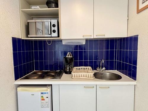 - une petite cuisine avec un évier et du carrelage bleu dans l'établissement Appartement 2 pièces cabine 4 couchages ARGELES SUR MER AR260-402, à Argelès-sur-Mer