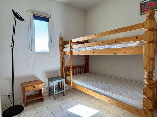 une chambre avec deux lits superposés et une lampe dans l'établissement Appartement 2 pièces cabine 4 couchages ARGELES SUR MER AR260-402, à Argelès-sur-Mer