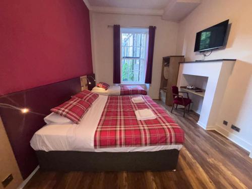 a bedroom with a bed with a red wall at Regent House Hotel - City Centre Hotel in Edinburgh