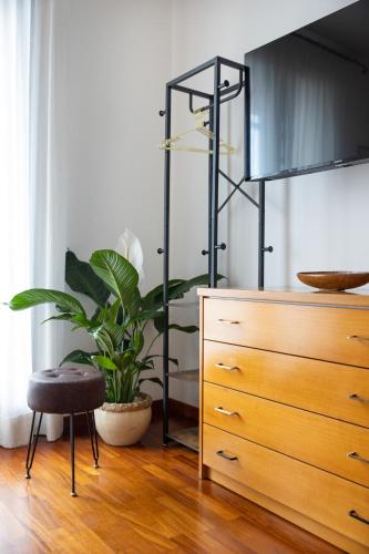 a bedroom with a dresser and a plant next to a dresser at Le Rose - Suites e Breakfast a 5 min dal mare e Misano World Circuit in Misano Adriatico